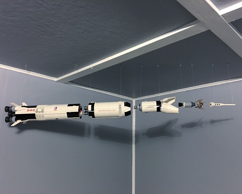 Lego Saturn V rocket separated into stages and hung in a line from the ceiling